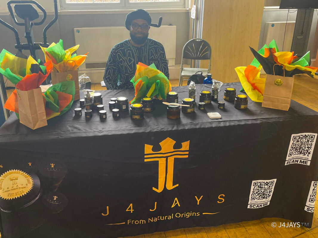 J4JAYS Stall showing the beautiful products with founder Jay Mullings sat behind the branded stall